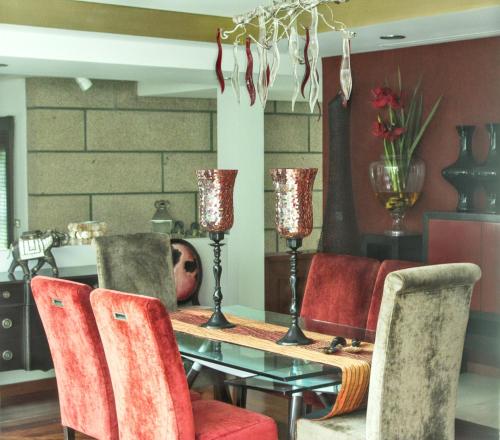 una sala da pranzo con tavolo e sedie rosse di 4 bedrooms villa with indoor pool jacuzzi and enclosed garden at Santo Tirso a Santo Tirso