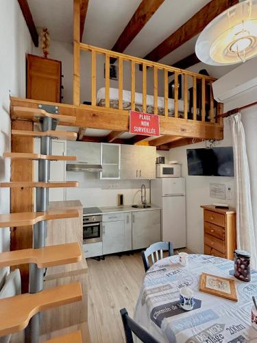 une cuisine et une salle à manger avec un lit en mezzanine dans l'établissement Bel appartement 4 ou 5 pers 150 m de la plage 5CL64, au Barcarès