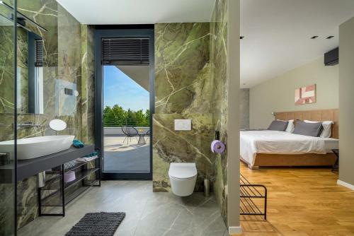 a bedroom with a bed and a bathroom with a sink at Villa She Luxury in Boškari