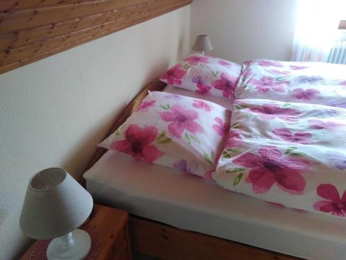 a bed with two pillows and a lamp in a bedroom at Ferienwohnung Fehncharme 85100 in Ostrhauderfehn