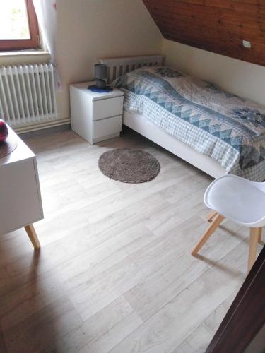 a bedroom with a bed and a wooden floor at Ferienwohnung Fehncharme 85100 in Ostrhauderfehn