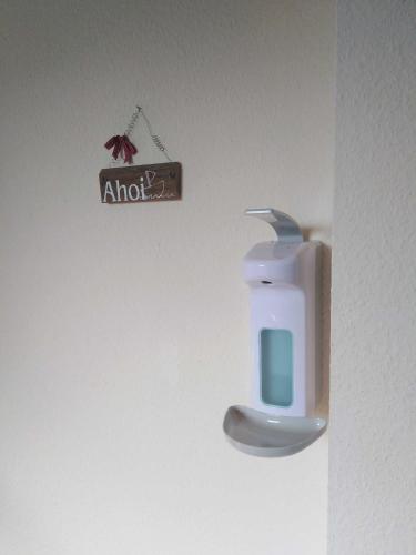 a sign hanging on a wall next to a door at Ferienwohnung Fehncharme 85100 in Ostrhauderfehn