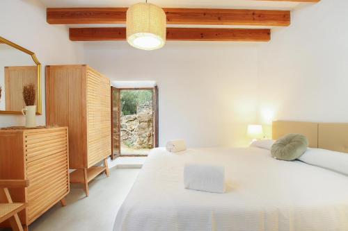 a bedroom with a large white bed and a window at Villa Alordes in Pollença