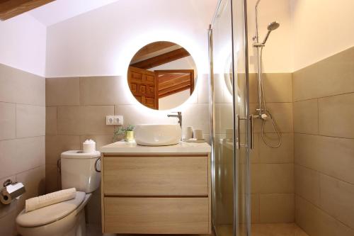a bathroom with a toilet and a sink and a mirror at Villa Alordes in Pollença