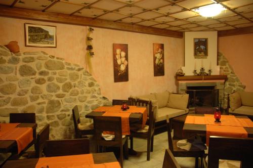 a restaurant with tables and chairs and a fireplace at Archontiko Mesohori Meteora in Kalabaka