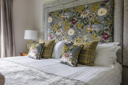 a bedroom with a bed with pillows and a floral headboard at Peak Edge Hotel in Chesterfield