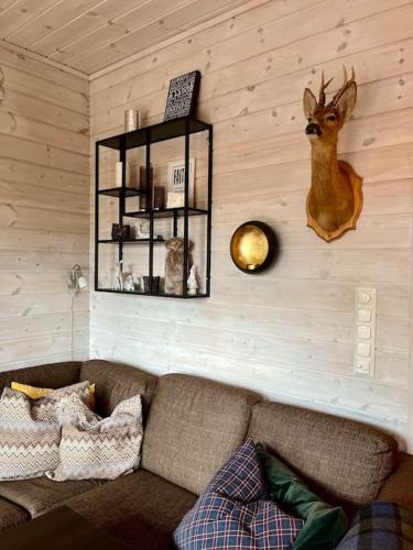 a living room with a couch and a deer head on the wall at Cozy Apartment near alpine and trails in Sirdal in Sinnes