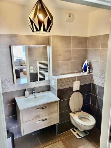 une salle de bain avec toilettes, lavabo et miroir dans l'établissement Superbe appartement au calme, à La Garde