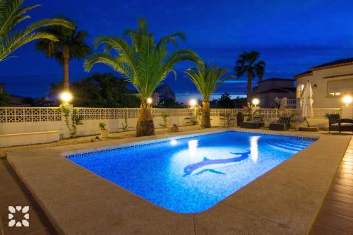 una mujer tendida en una piscina por la noche en Villa Mackay by Abahana Villas, en Calpe