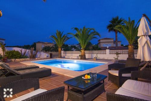 una piscina en un patio trasero con palmeras en Villa Mackay by Abahana Villas, en Calpe