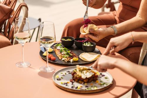 a group of people sitting at a table with a plate of food at BLESS Hotel Ibiza - The Leading Hotels of The World in Es Cana