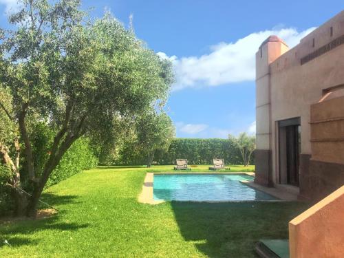 uma piscina num quintal ao lado de uma casa em 3 bedrooms villa with private pool and enclosed garden at Marrakech em Douar bel Rhanodour