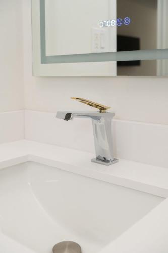a bathroom sink with a faucet and a mirror at Diplomat Inn in Niagara Falls