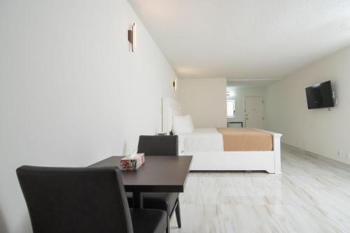 a bedroom with a bed and a desk and a bed at Diplomat Inn in Niagara Falls