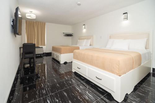 um quarto de hotel com duas camas e uma secretária em Diplomat Inn em Cataratas do Niágara
