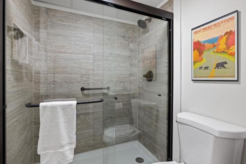 a bathroom with a glass shower with a toilet at Beary Convenient is a Newly Renovated King Suite Condo in the heart of Gatlinburg with pools in Gatlinburg