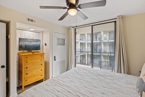 a bedroom with a bed and a ceiling fan at Beary Convenient is a Newly Renovated King Suite Condo in the heart of Gatlinburg with pools in Gatlinburg