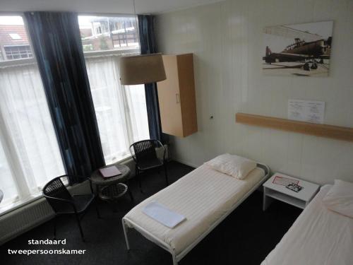 a hospital room with two beds and a plane on the wall at Hotel 't Anker in Leeuwarden