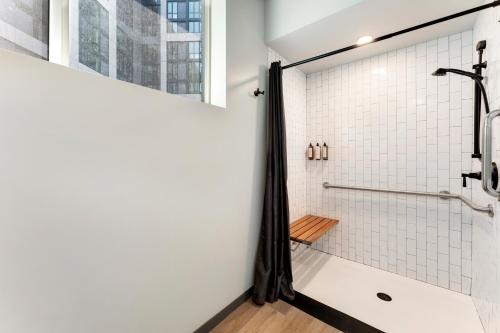 a bathroom with a shower with white tiles at Hotel Nell - Union Market in Washington