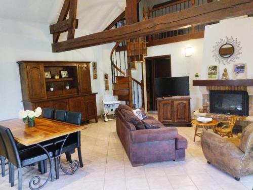 a living room with a couch and a table at Maison traditionnelle Normande avec piscine in Hotot-en-Auge