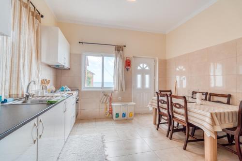 a kitchen with a table and a dining room at Cantinho da Portada in Seixal