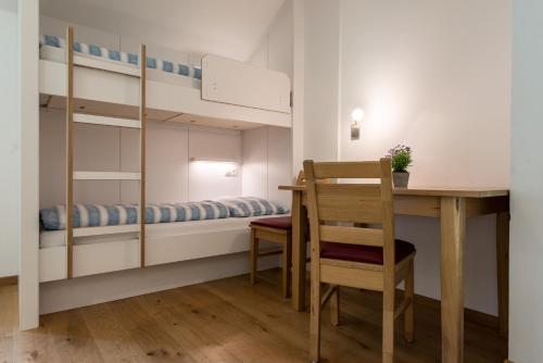 Kleines Zimmer mit einem Schreibtisch und einem Etagenbett. in der Unterkunft Pension Tannenhof in St. Johann im Ahrntal