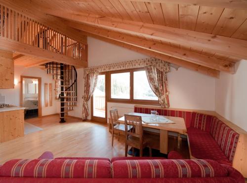 uma sala de estar com um sofá vermelho e uma mesa em L'GROF - AL CONTE em San Martino in Badia