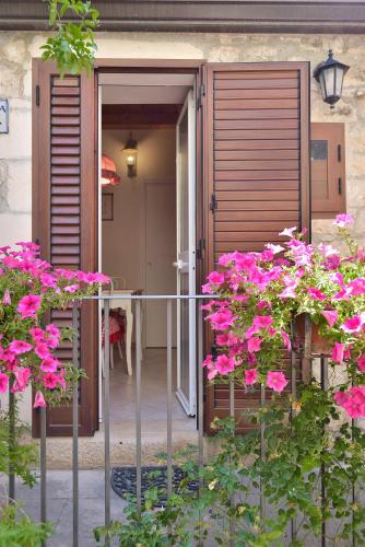 a balcony with pink flowers in front of a house at Case del Vicolo Stretto in Modica