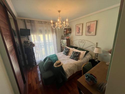 una camera da letto con un letto, una sedia e un lampadario di Casa As Bateas a Sada