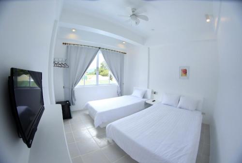 A bed or beds in a room at Bluewave Hotel