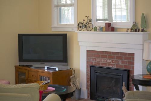 a living room with a television and a fireplace at Once Upon A Time by Seabrook Hospitality in Pacific Beach