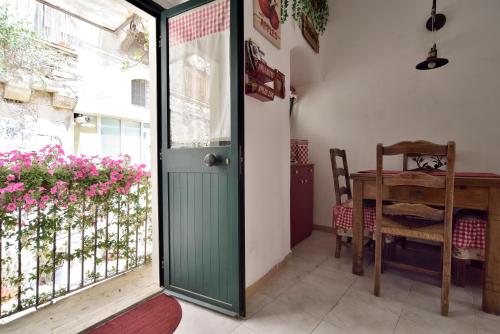a green door in a room with a table and a window at Case del Vicolo Stretto in Modica