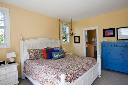 a bedroom with a white bed and a blue dresser at Once Upon A Time by Seabrook Hospitality in Pacific Beach