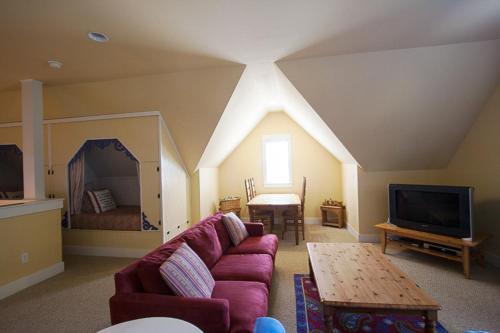 a living room with a couch and a tv at Once Upon A Time by Seabrook Hospitality in Pacific Beach