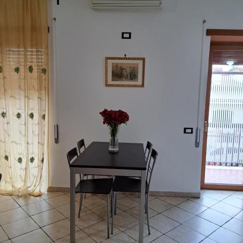 a dining room table with a vase of flowers on it at La Casa di Ale - Castelli Romani in Marino