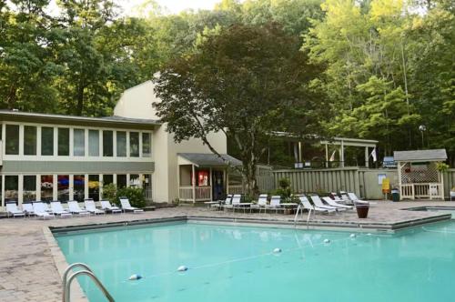 a swimming pool with chairs and a house at Obear Mountain is a Newly Updated Condo in Chalet Village of Gatlinburg! in Gatlinburg