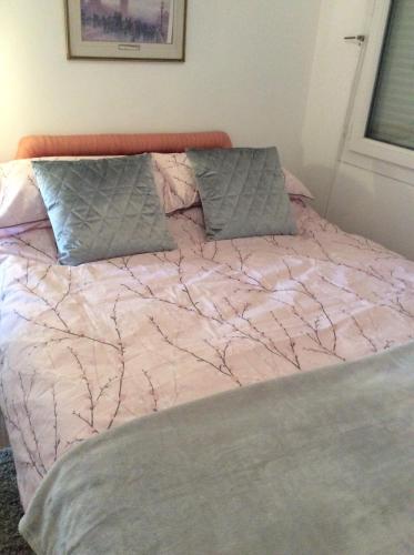 - un lit avec une couette rose et 2 oreillers dans l'établissement 10 Rue Bardeau,Fougerolle du Plessis,France,53190, à Fougerolles-du-Plessis