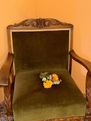 a bouquet of flowers sitting on a green chair at Casa Costa Laspaúles in Laspaúles