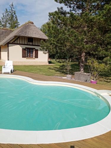 une image d'une piscine en face d'une maison dans l'établissement Maison traditionnelle Normande avec piscine, à Hotot-en-Auge