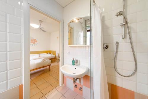 a bathroom with a sink and a shower and a bed at Il Villaggio di ABITABO in Bologna