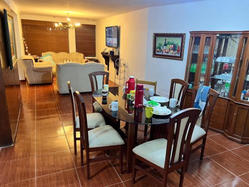 ein Esszimmer mit einem Tisch und Stühlen sowie ein Wohnzimmer in der Unterkunft Casa Huaraz zona tranquila, con amplio jardin interior horno - parrilla in Huaraz