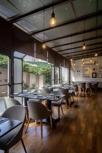 a dining room with tables and chairs and windows at Hotel Almería in Salta