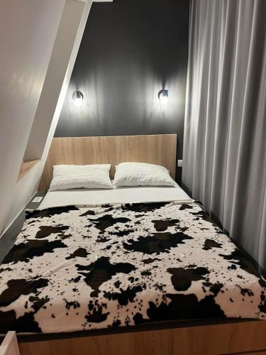 a bedroom with a bed with a black and white rug at Apartmani VinVucko Jahorina u sklopu aparthotela Vucko privatni apartmani in Jahorina