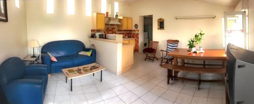 ein Wohnzimmer mit einem blauen Sofa und einem Tisch in der Unterkunft Maison de 2 chambres avec jardin clos et wifi a Berriac in Berriac