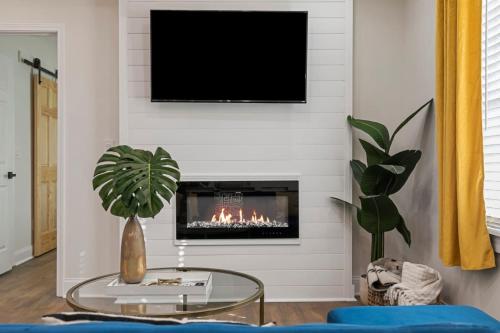 a living room with a fireplace with a flat screen tv at Westside Charm in Atlanta