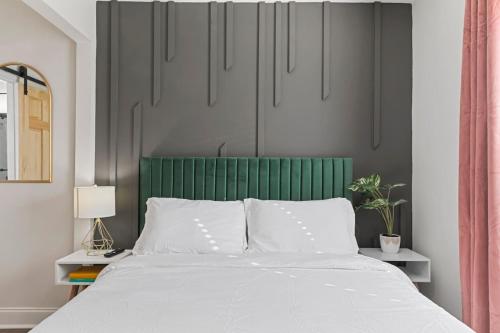 a bedroom with a bed with a green headboard at Westside Charm in Atlanta