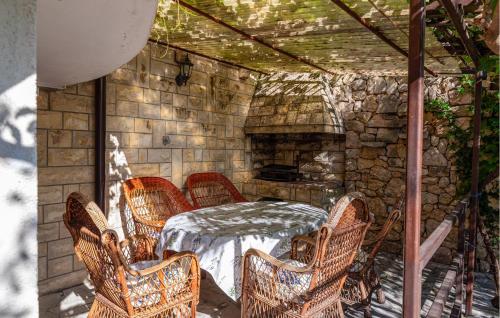 a patio with a table and chairs and a stone fireplace at Lovely Apartment In Rovanjska in Rovanjska