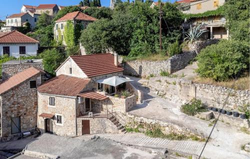 an old stone house with an umbrella in a village at 1 Bedroom Gorgeous Home In Vrisnik in Vrisnik