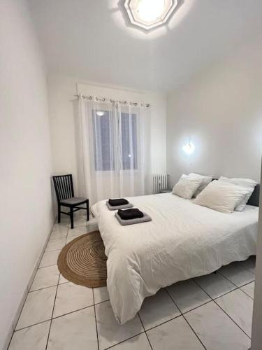 una camera da letto bianca con un letto grande e una sedia di Le 43 location bord de mer a Marsiglia