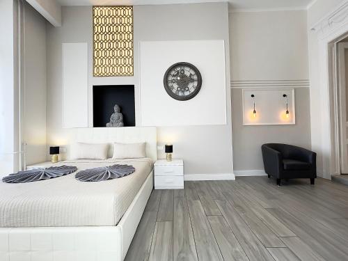 a bedroom with a bed and a black chair at Trigon Palace in Budapest